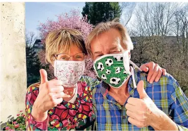  ?? FOTO: KLAUS MANS ?? Ohne gehen sie nicht mehr aus dem Haus. Susanne und Klaus Mans aus Düsseldorf schützen sich mit Mundschutz­masken, die ihre Tochter Rebecca genäht hat.