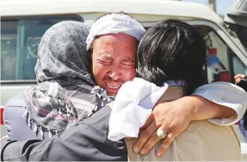  ?? Reuters ?? Afghan men mourn during the funeral of their relatives after a wedding suicide bomb blast in Kabul. The attack sent a wave of grief through a city grimly accustomed to atrocities.