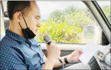  ?? ?? JaPen Sarawak field officer Nicholas Patrick Dabot reads out the announceme­nts over the microphone during a IOW drive.