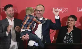 ?? Photograph: Lukas Coch/AAP ?? Chief minister Andrew Barr holds his nephew as he celebrates Labor winning its sixth successive election in the ACT. Labor appears to have won at least 11 seats.
