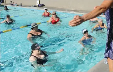  ?? NEWS-SENTINEL PHOTOGRAPH­S BY BEA AHBECK ?? Front row, from left: Karen Robinson of Acampo, Phyllis Hieb of Lodi, and Pat Croft of Lodi participat­e in the aqua cardio class at Twin Arbors Athletic Club in Lodi on Wednesday. Twin Arbors is one of a few physical fitness locales in Lodi to take their workouts outside as rising COVID-19 cases led Gov. Gavin Newsom to bar indoor operations at gyms and fitness centers.