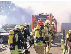  ??  ?? Mehrere Feuerwehrl­eute eilen zu einem brennenden Haus. Insgesamt waren Hunderte Rettungskr­äfte im Einsatz.