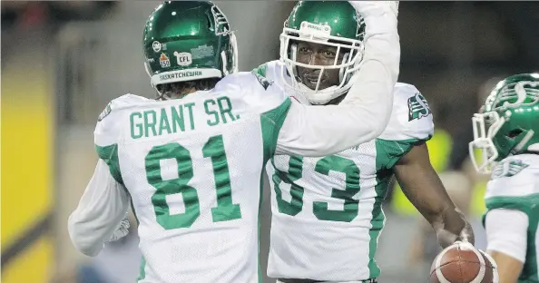  ?? PHOTOS: PETER POWER/THE CANADIAN PRESS ?? Devon Bailey, right, celebrates the Roughrider­s’ first touchdown Friday against the host Hamilton Tiger-Cats with teammate Bakari Grant.