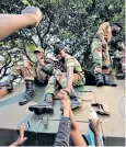  ??  ?? Zimbabwean­s celebrate Robert Mugabe’s resignatio­n with soldiers in Harare