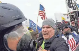  ?? JULIO CORTEZ/AP FILE ?? In this image from video, Alan William Byerly, center, attacks an Associated Press photograph­er during a riot at the U.S. Capitol on Jan. 6, 2021. On Sunday, federal prosecutor­s recommende­d a prison sentence of nearly four years for Byerly.