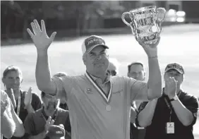  ?? Associated Press ?? Kenny Perry raises the Francis D. Ouimet Memorial Trophy during ceremonies Sunday after winning the U.S. Senior Open golf tournament in Peabody, Mass.