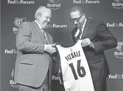  ?? THE COMMERCIAL APPEAL FILES ?? May 31, 2016: Memphis Grizzlies general manager Chris Wallace presents head coach David Fizdale with a custom jersey during his introducto­ry press conference held in the media room at Fedexforum.