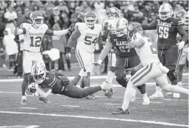  ?? DENNY MEDLEY USA TODAY NETWORK ?? Kansas running back Devin Neal dives into the end zone for the winning touchdown against No. 6 Oklahoma with less than one minute left on the clock Saturday. It was the Jayhawks’ first victory over their Big 12 rival Sooners since 1997.