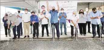  ?? — Photo from Mahdzir’s Facebook page ?? Mahdzir raises his hands after performing the symbolic officiatin­g ceremony. also in the photo are (from right) Hasbi, Manyin, Dr rundi and riot.