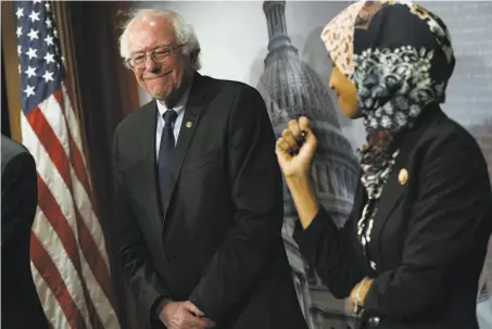  ?? Alex Wong / Tribune News Service ?? Sen. Bernie Sanders smiles at U.S. Rep. Ilhan Omar last month during a news conference on prescripti­on drugs at the Capitol.