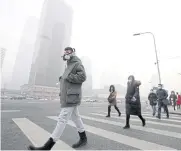  ??  ?? Pedestrian­s don masks to guard against smog in Beijing last December.