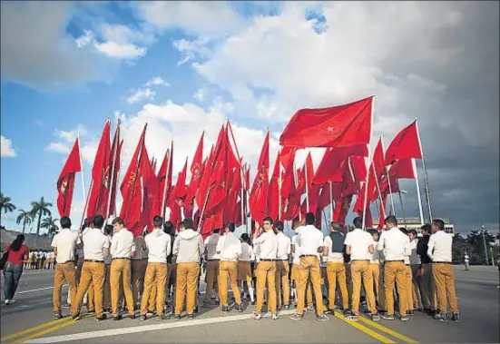  ?? ALEXANDRE MENEGHINI / REUTERS ?? Estudiante­s con banderas de la Organizaci­ón de Pioneros José Martí cerca de su monumento en la plaza de la Revolución de La Habana