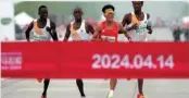  ?? [Photo/ Agencies] ?? Chinese runner He Jie, Ethiopian Dejene Hailu Bikila and Kenyans Robert Keter and Willy Mnangat take part in a half-marathon in Beijing, China April 14, 2024.