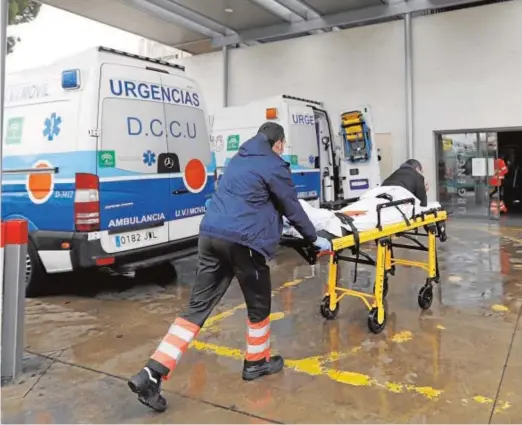  ??  ?? Un sanitario empuja una camilla con un paciente hacia la puerta de acceso al área de Urgencias del Reina Sofía