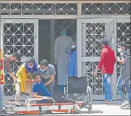  ?? AFP ?? A Covid-19 patient being helped by his relatives outside a Covid ward at a hospital in New Delhi on Tuesday.