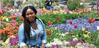  ?? Photo: Bev Lacey ?? STUNNING DISPLAYS: Muma Bwalya in the Botanic Gardens at Queens Park during the 2017 Carnival of Flowers.