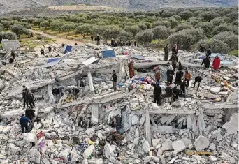  ?? Ghaith Alsayed/Associated Press ?? Civil defense workers and residents search through the rubble of collapsed buildings in the town of Harem near the Turkish border, Idlib province, Syria, on Monday.