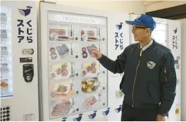  ?? KWIYEON HA/AP ?? Konomu Kubo of Kyodo Senpaku Co. shows off a whale meat vending machine Jan. 26 in Japan. The company wants to set up 100 machines in the next five years.