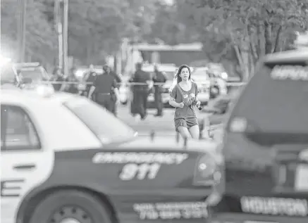  ?? Mark Mulligan / Houston Chronicle ?? Jennifer Molleda runs down Weslayan Street in search of her husband, Alan Wakim, who had two bullets whiz by his face after going through his windshield while he was on his way to work last Monday.