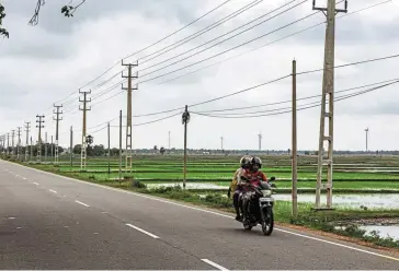  ?? — Bloomberg ?? Mixed bag: Wind turbines and electricit­y towers along a highway in southern India. Power utility Adani Transmissi­on’s profit fell 25% to 2.06 billion rupees (Rm115.9mil) despite a 22% rise in revenue as costs surged in the quarter ended Sept 30.