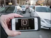  ?? The Canadian Press ?? Ride-hailing companies could begin operations in B.C. by next fall under legislatio­n introduced Monday.The Uber logo is seen in front of protesting taxi drivers at the courthouse in Montreal.