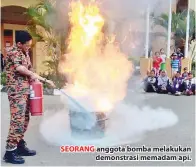  ??  ?? SEORANG anggota bomba melakukan demonstras­i memadam api.