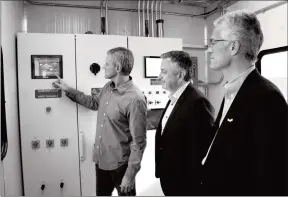  ?? Herald photo by Tim Kalinowski ?? EnviroFlam­e Technologi­es president Grant Stegen (left) shows off his company’s new oilfield water heating engine for BDC senior vice-president Michael Selsi and BDC president and CEO Michael Denham on Thursday. Denham was in town to help mark Small Business Week in Lethbridge.