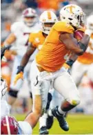 ?? AP PHOTO/WADE PAYNE ?? Tennessee defensive lineman Kyle Phillips runs an intercepti­on back for a touchdwon against Alabama on Saturday.