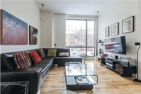  ?? PHOTOS: DARIO AYALA ?? The living room at the home of Lyne Arcand in Little Italy has a black leather sectional sofa and a glass-topped coffee table and light streams in from a large window.