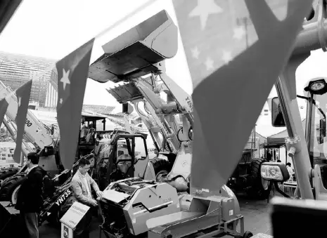  ?? REUTERS ?? Chinese flags are seen in front of constructi­on vehicles during the China Import and Export Fair, also known as Canton Fair, in the southern city of Guangzhou, China.