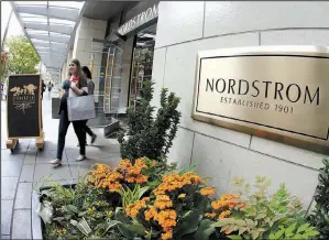  ?? AP/TED S. WARREN ?? Shoppers exit Nordstrom’s flagship store in downtown Seattle in September. The department store chain said Monday it is temporaril­y halting its plan to take the company private.