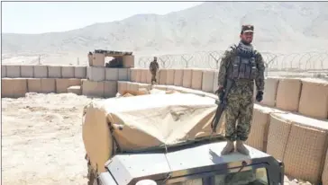  ?? DAN LAMOTHE/THE WASHINGTON POST ?? Afghan soldiers scan their surroundin­gs at an outpost on the outskirts of Kabul that had been attacked the previous week by Taliban fighters.