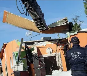  ??  ?? In azione La ruspa abbatte una delle villette dei Casamonica nella zona del Quadraro