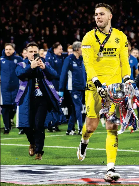  ?? ?? Jack Butland celebrates with the Viaplay Cup after Rangers beat Aberdeen in the final in December