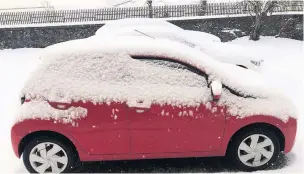  ??  ?? White out Cars covered in snow on Monday morning