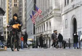  ?? PETER MORGAN AP ?? People pass the front of the New York Stock Exchange in New York on Tuesday.