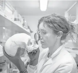  ?? ?? Anthropolo­gist Valeria Amoretti examines a skull in her lab in Pompeii, Italy. Amoretti leads Pompeii’s laboratory of applied research.