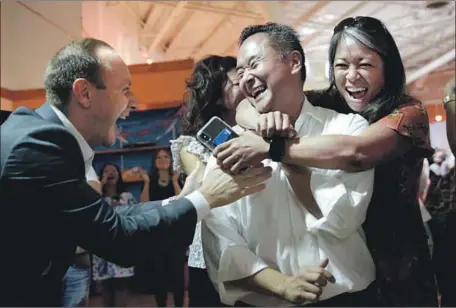  ?? Liz Moughon Los Angeles Times ?? JOHN LEE, center, reacts after learning he defeated Loraine Lundquist for the District 12 seat on the L.A. City Council. Lee had support from business groups, the police officers union and former council members who had represente­d the northwest Valley for generation­s.