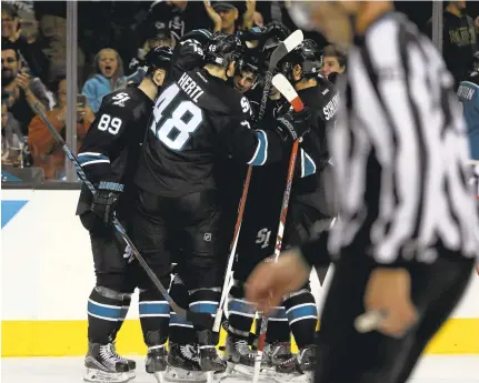  ?? NHATV. MEYER/STAFF PHOTOS ?? Tomas Hertl and his Sharks teammates pile on Joonas Donskoi, center, after Donskoi opened the game’s scoring with a goal in the first period.