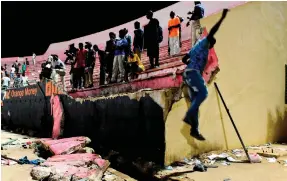  ?? Seyllou / EPA ?? Spectators fled from tear gas rounds fired by police at the stadium in Dakar, prompting a wall to give way and crush fans below