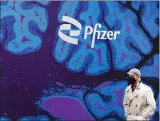  ?? AP FILE ?? PAIN PICKUP; A man walks by Pfizer headquarte­rs in 2021 in New York. Pfizer is spending more than $11 billion to buy the remaining portion of migraine treatment maker Biohaven Pharmaceut­icals it does not already own.