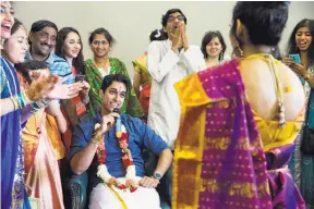  ??  ?? Mukundan (center) jokes with his bride (back to camera) during the nalangu portion of their wedding, where traditiona­l games are played between the couple to bring in a lightheart­ed element and relieve the stress of the long day.