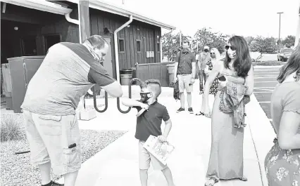  ?? Photos by Jennifer Rios, Broomfield Enterprise ?? Chris Ott says goodbye and bumps elbows with Rocco Wilcox after a children’s church program at Discovery Christian Church as his mother looks on.