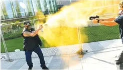  ?? HELEN H. RICHARDSON/ THE DENVER POST VIA AP ?? A man sprays mace, left, as another man fires a gun Saturday in Denver. The man on the left side of the photo was supporting the “Patriot Rally.”