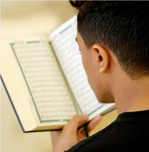  ?? — Photo by M. Sajjad ?? A man reads the Holy Quran after offering Asr prayers at Al Noor Mosque in Sharjah during the holy month.