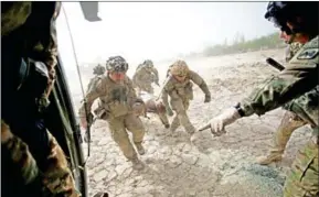  ?? JOHANNES EISELE/AFP ?? Medics carry a stretcher with a heavily wounded US soldier after he was brought by Medevac of 159th Brigade Task Force Thunder to Kandahar Hospital Role in 2011.