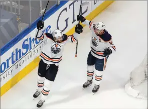  ?? The Associated Press ?? Edmonton Oilers Leon Draisaitl and Connor McDavid celebrate a goal against the Chicago Blackhawks in Edmonton, Aug. 5.