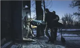  ?? ?? MILITARY medics carry the body of a Ukrainian comrade into a morgue in Donetsk. Russian troops have struggled to gain control over the region.