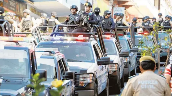  ?? Eduardo Murillo AFP/Getty Images ?? A CONVOY of law enforcemen­t arrives in Jalapa, Veracruz state, to bolster security. A recent rash of killings has raised questions about the U.S. role in the drug war.