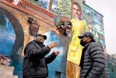  ?? — Washington Post photo by Michael S. Williamson ?? Ligon, left, takes a tour of his new neighborho­od with John Pace, a former juvenile lifer himself who works as a reentry coordinato­r for the Youth Sentencing & Reentry Project. The mural was created by inmates from the now-shuttered Graterford prison, where Ligon and Pace served time together.